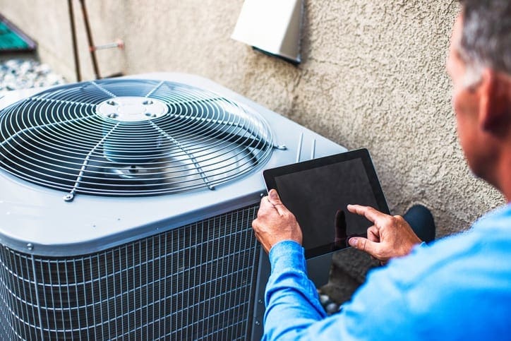 Kevin Robinson's Heating & Cooling | Lancaster, Kershaw, Lugoff, Camden, Indian Land, Heath Springs, SC | Maintenance engineer using digital tablet to inspect air conditioning unit